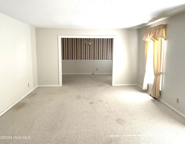 carpeted spare room featuring a textured ceiling