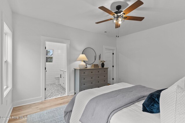 bedroom featuring ensuite bath, ceiling fan, and light hardwood / wood-style flooring