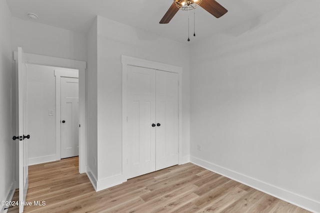 unfurnished bedroom featuring ceiling fan, light hardwood / wood-style floors, and a closet