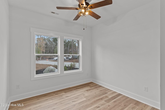 empty room with ceiling fan and light hardwood / wood-style flooring