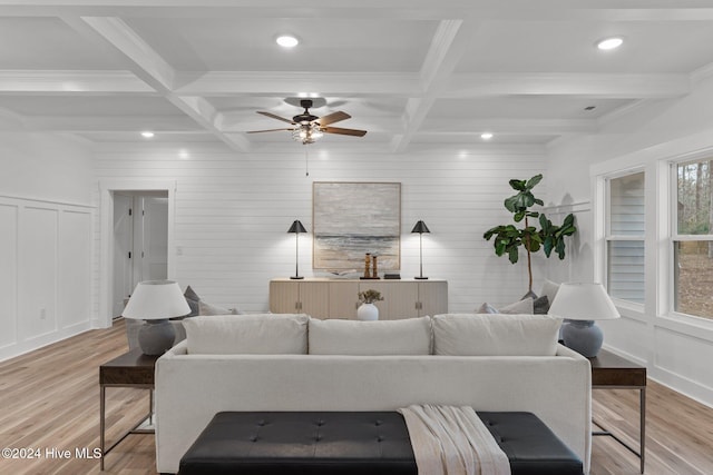 living room with beam ceiling, ceiling fan, coffered ceiling, and light wood-type flooring