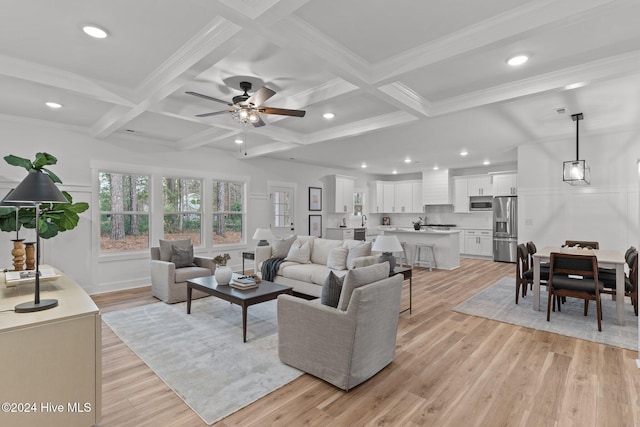 living room with coffered ceiling, light hardwood / wood-style flooring, ceiling fan, ornamental molding, and beamed ceiling