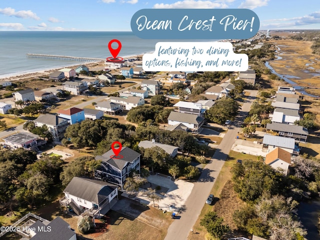 birds eye view of property with a water view and a beach view