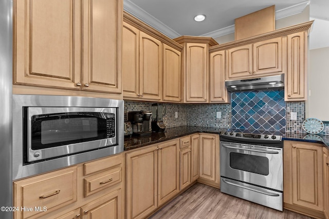 kitchen featuring light brown cabinets, decorative backsplash, dark stone countertops, ornamental molding, and appliances with stainless steel finishes