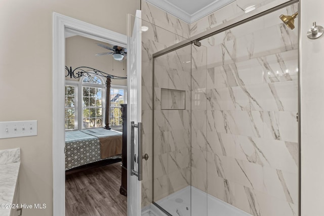 full bathroom with connected bathroom, wood finished floors, a ceiling fan, ornamental molding, and a marble finish shower