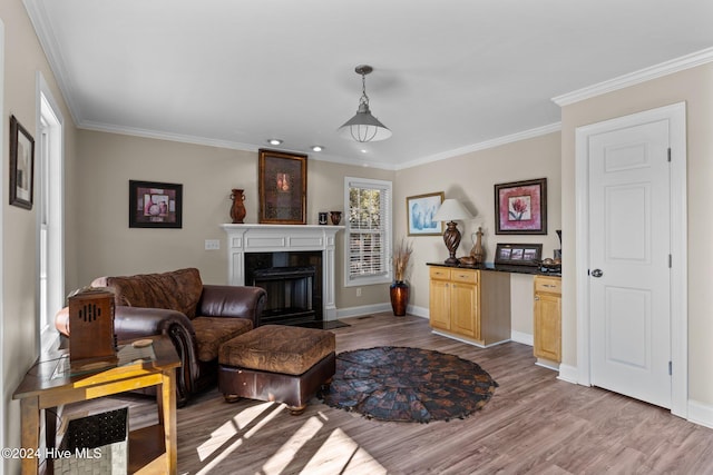 living room featuring light wood-style flooring, ornamental molding, and a fireplace with flush hearth