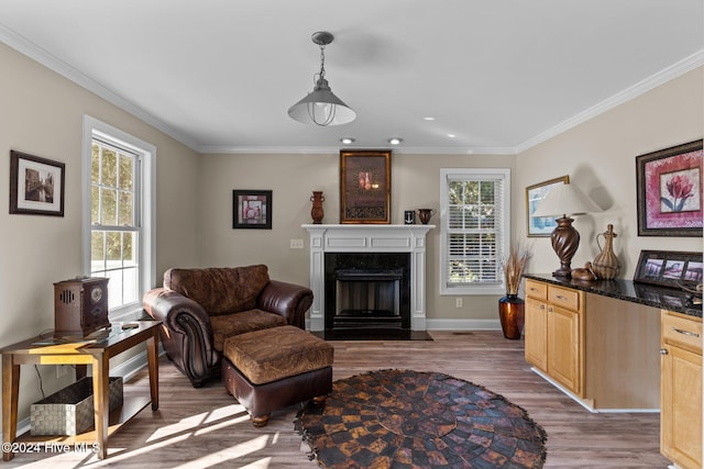 living area with a wealth of natural light, crown molding, and wood finished floors