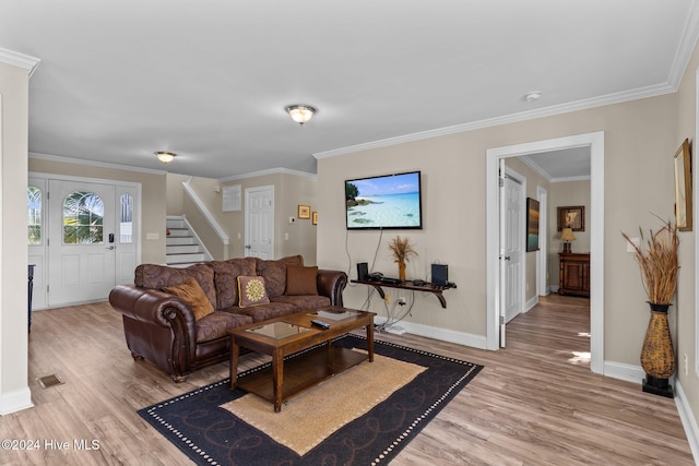 living area featuring light wood-style floors, baseboards, stairway, and crown molding