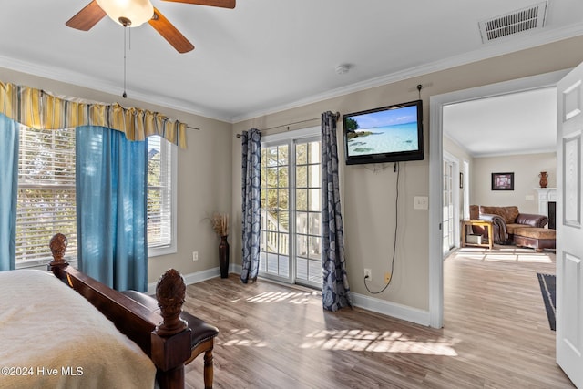 bedroom with access to outside, multiple windows, visible vents, and crown molding