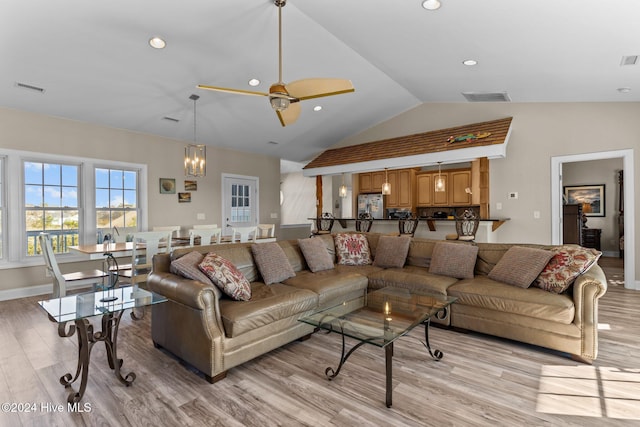 living room featuring ceiling fan, light hardwood / wood-style flooring, and lofted ceiling