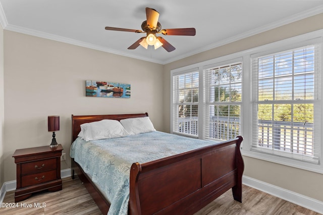 bedroom featuring light wood-style floors, multiple windows, and crown molding