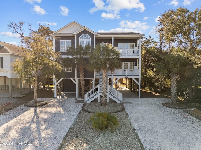 beach home with stairs, a carport, and a balcony