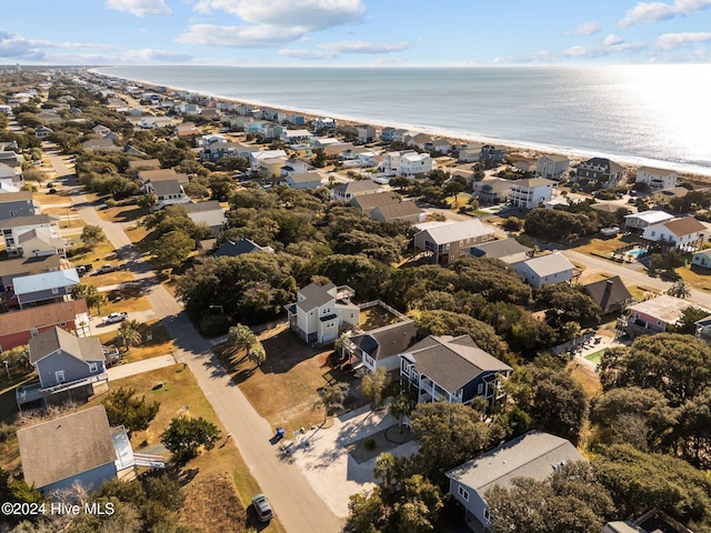 birds eye view of property with a water view and a beach view