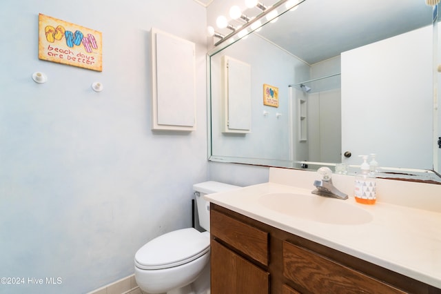 bathroom featuring walk in shower, vanity, and toilet