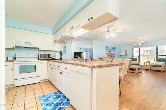 kitchen featuring white cabinets, white appliances, kitchen peninsula, and light hardwood / wood-style flooring