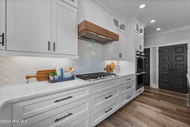 kitchen featuring premium range hood, white cabinets, crown molding, dark hardwood / wood-style floors, and stainless steel appliances