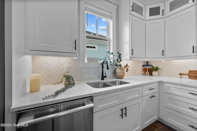 kitchen featuring dishwasher, backsplash, white cabinetry, and sink