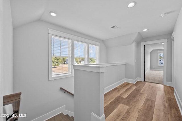 hallway featuring light hardwood / wood-style flooring and lofted ceiling