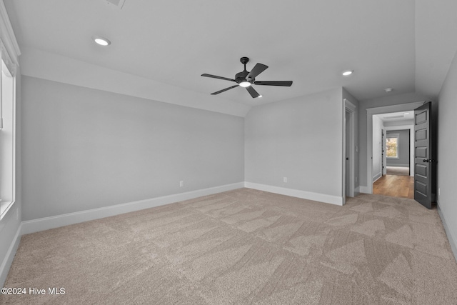 unfurnished room with ceiling fan, light carpet, and vaulted ceiling