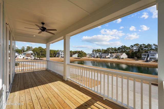 wooden deck featuring ceiling fan, a water view, and covered porch