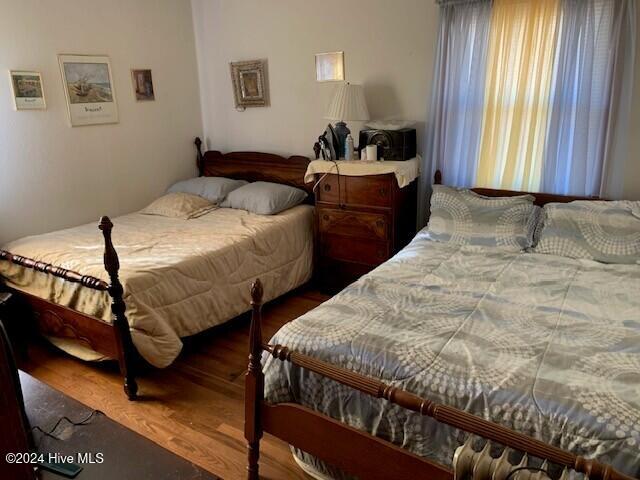 bedroom with dark hardwood / wood-style floors