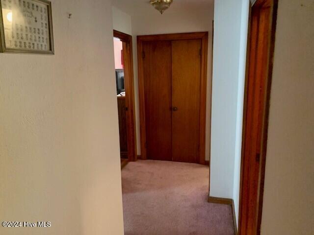 hallway featuring light colored carpet