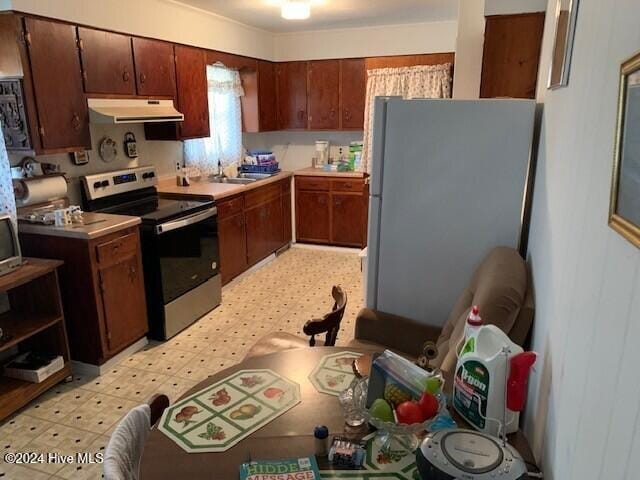 kitchen featuring white fridge, stainless steel electric range oven, and sink