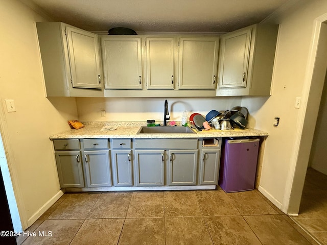 kitchen with dishwasher, crown molding, gray cabinetry, and sink