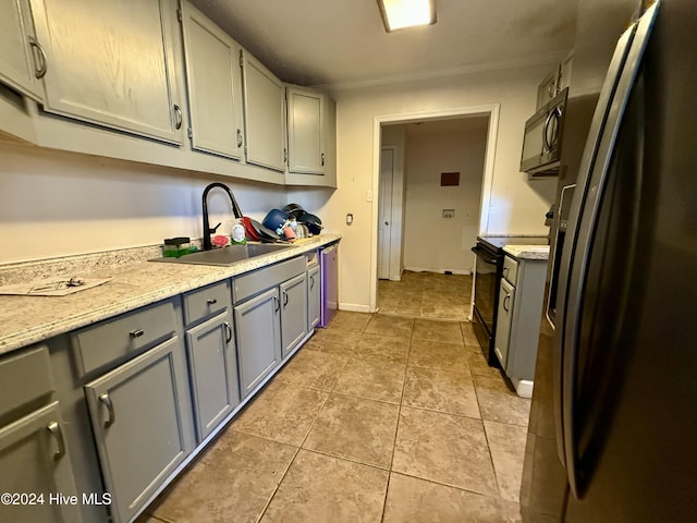 kitchen featuring sink, light tile patterned floors, and stainless steel appliances