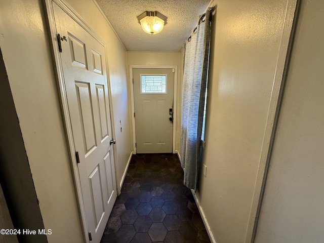 doorway to outside with a textured ceiling