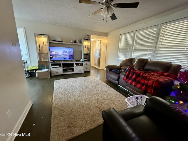 living room with dark hardwood / wood-style floors, ceiling fan, a textured ceiling, and a wealth of natural light