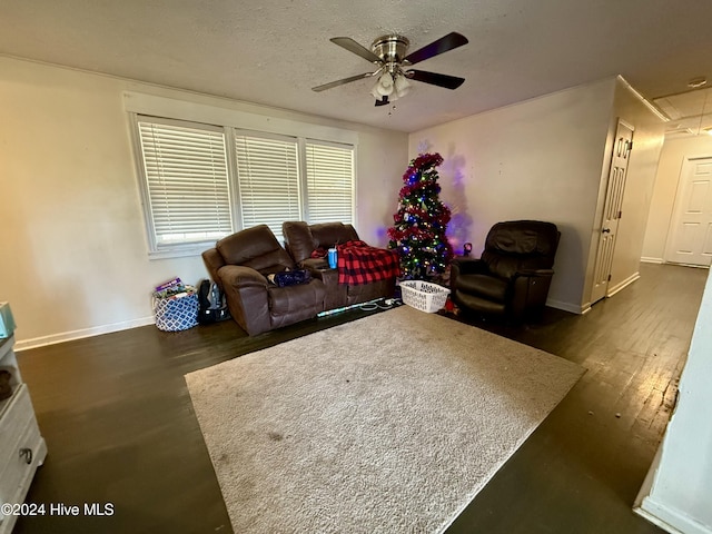 living room with a textured ceiling, dark hardwood / wood-style floors, and ceiling fan