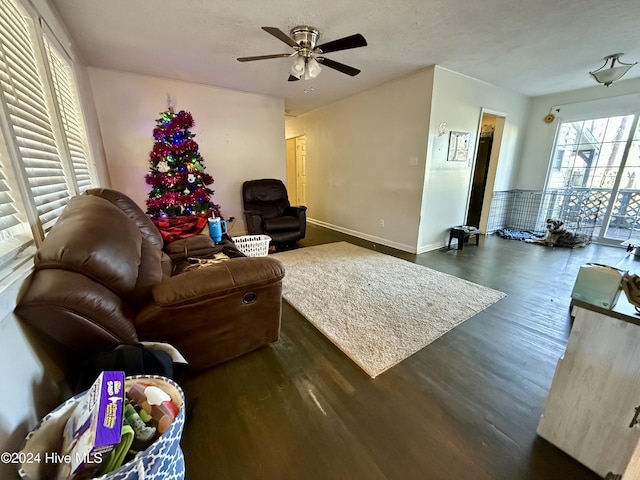 living room featuring ceiling fan and dark hardwood / wood-style flooring