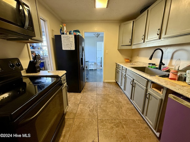 kitchen featuring crown molding, sink, black appliances, light tile patterned floors, and gray cabinets