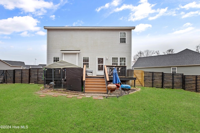 rear view of house featuring a yard and a wooden deck