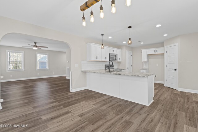 kitchen featuring stainless steel dishwasher, sink, pendant lighting, light hardwood / wood-style flooring, and white cabinetry