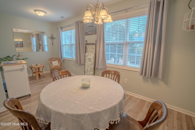 dining area with a chandelier, a healthy amount of sunlight, and light hardwood / wood-style flooring