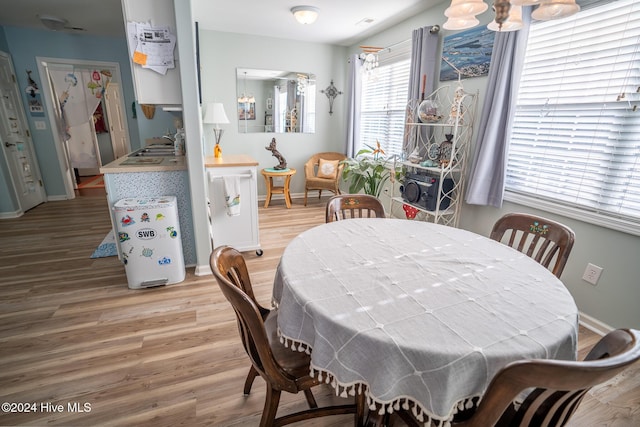 dining space featuring a notable chandelier, light hardwood / wood-style flooring, and sink