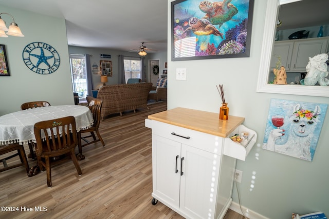 dining space with ceiling fan and light wood-type flooring