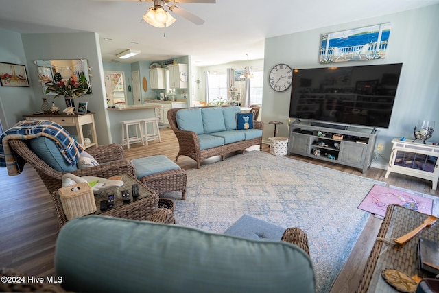 living room featuring hardwood / wood-style floors and ceiling fan with notable chandelier