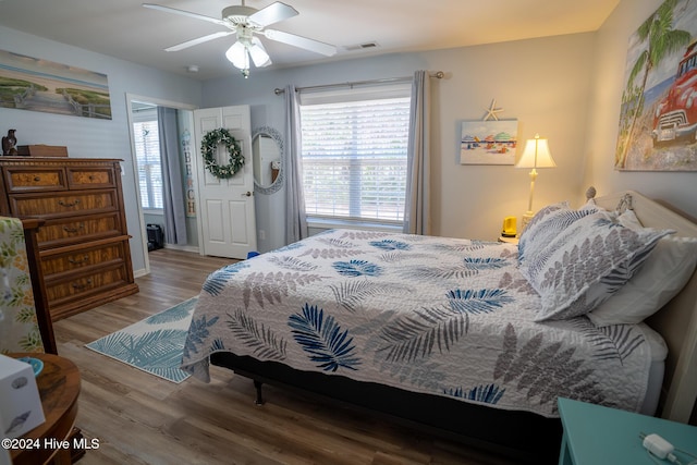 bedroom with hardwood / wood-style flooring, multiple windows, and ceiling fan