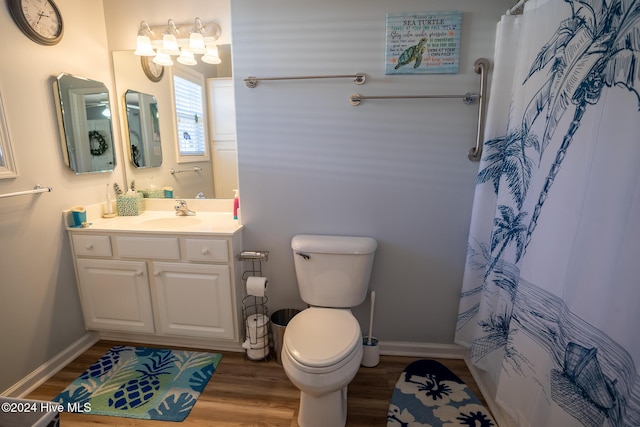 bathroom featuring hardwood / wood-style floors, toilet, walk in shower, and vanity