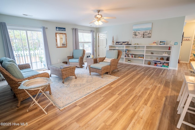 living area featuring ceiling fan, hardwood / wood-style floors, and plenty of natural light