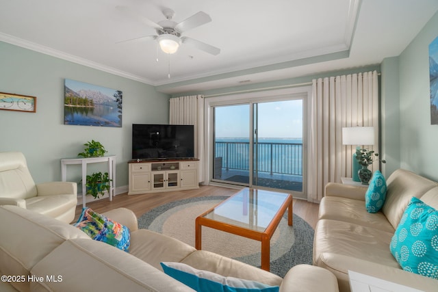 living area featuring light wood-style flooring, crown molding, and ceiling fan