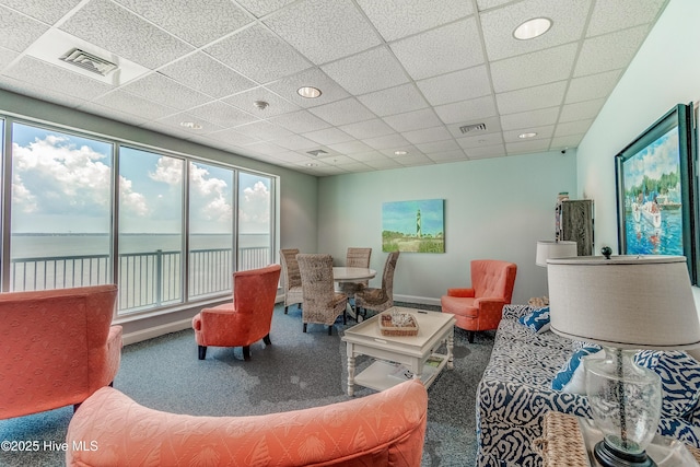 living room with visible vents, a drop ceiling, a water view, and carpet floors