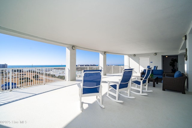 view of patio with a balcony and a water view