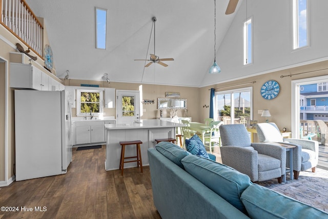 living room featuring dark hardwood / wood-style flooring, high vaulted ceiling, ceiling fan, and sink