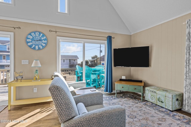 living room with hardwood / wood-style flooring, crown molding, and lofted ceiling