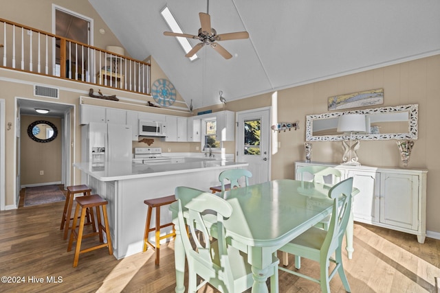 dining area with light wood-type flooring, high vaulted ceiling, ceiling fan, and sink