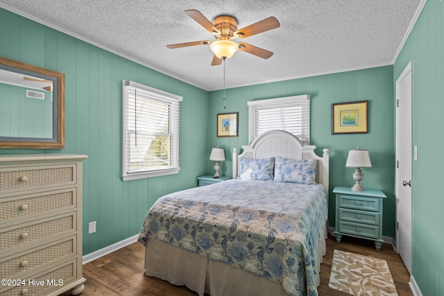 bedroom featuring ceiling fan, dark hardwood / wood-style flooring, a textured ceiling, and ornamental molding